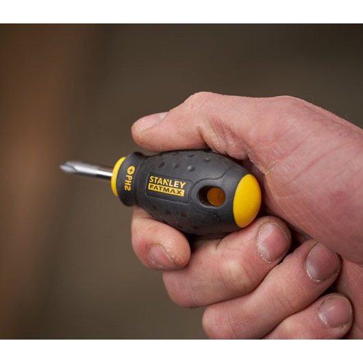 Stanley 0-65-407 stubby screwdriver with black and yellow FATMAX handle held in hand, PH2 tip visible.