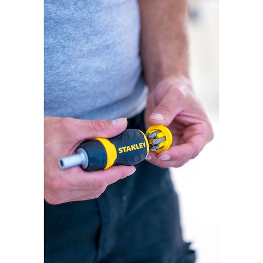 Photo of STANLEY 0-66-358 screwdriver with yellow and black handle, showing bit storage compartment open.