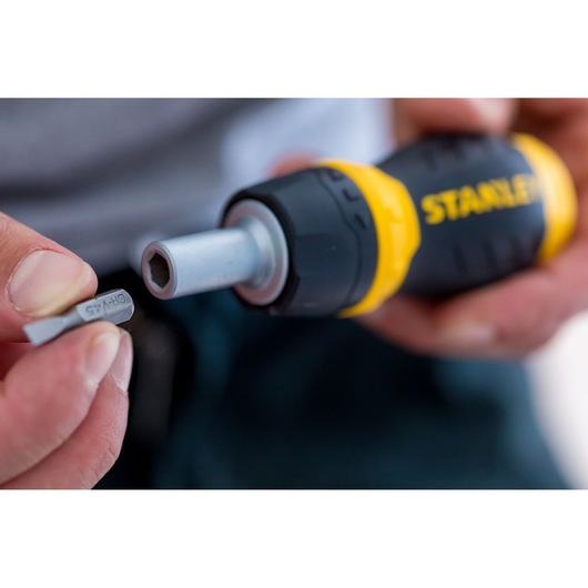 Close-up of STANLEY 0-66-358 screwdriver handle and interchangeable bit, hand-held, photography of product in use.