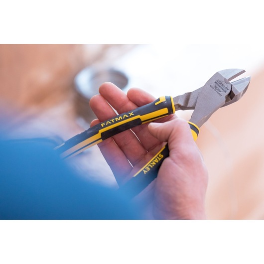 STANLEY 0-89-859 diagonal cutting pliers with black and yellow FATMAX handles held in hand.