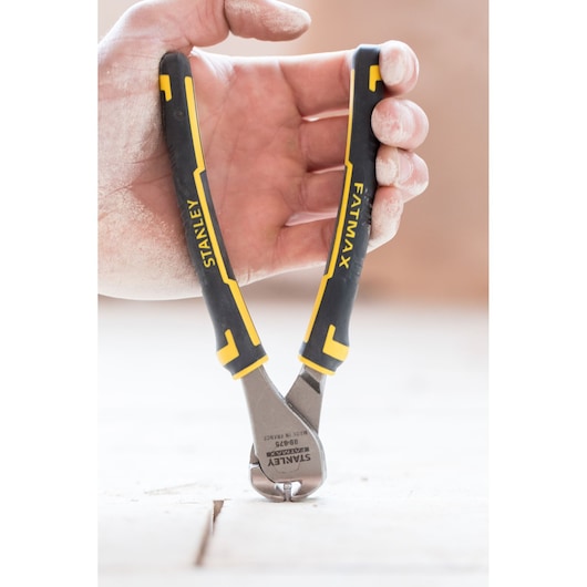Photo of STANLEY 0-89-875 hand-held end cutting pliers with black and yellow handles, shown in use.