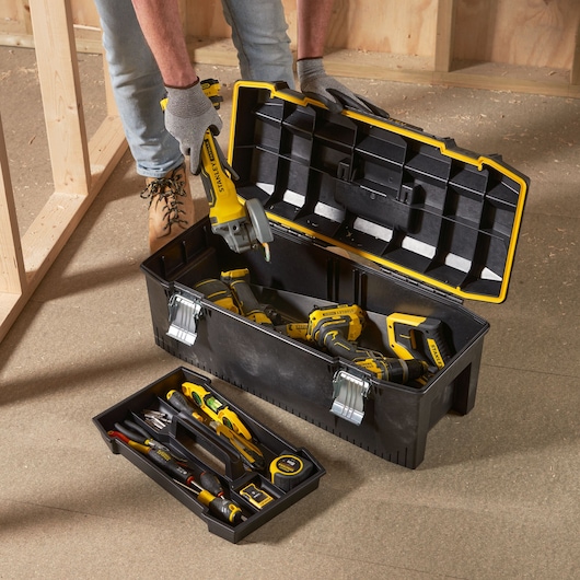 STANLEY 1-93-935 toolbox with hand tools and power tools, open on a workshop floor, photography angle from above.