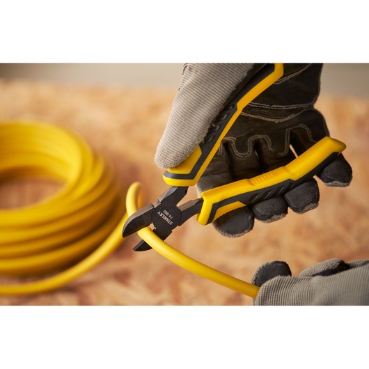 STANLEY STHT0-74455 diagonal cutting pliers cutting yellow cable, close-up outdoor photography.