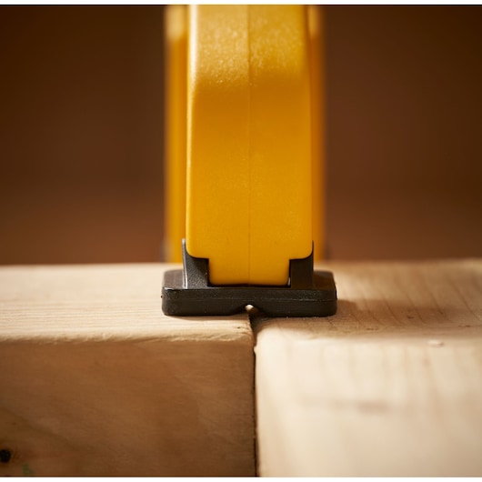 STANLEY STHT0-83199 yellow tool base on wood in close-up front angle photography.